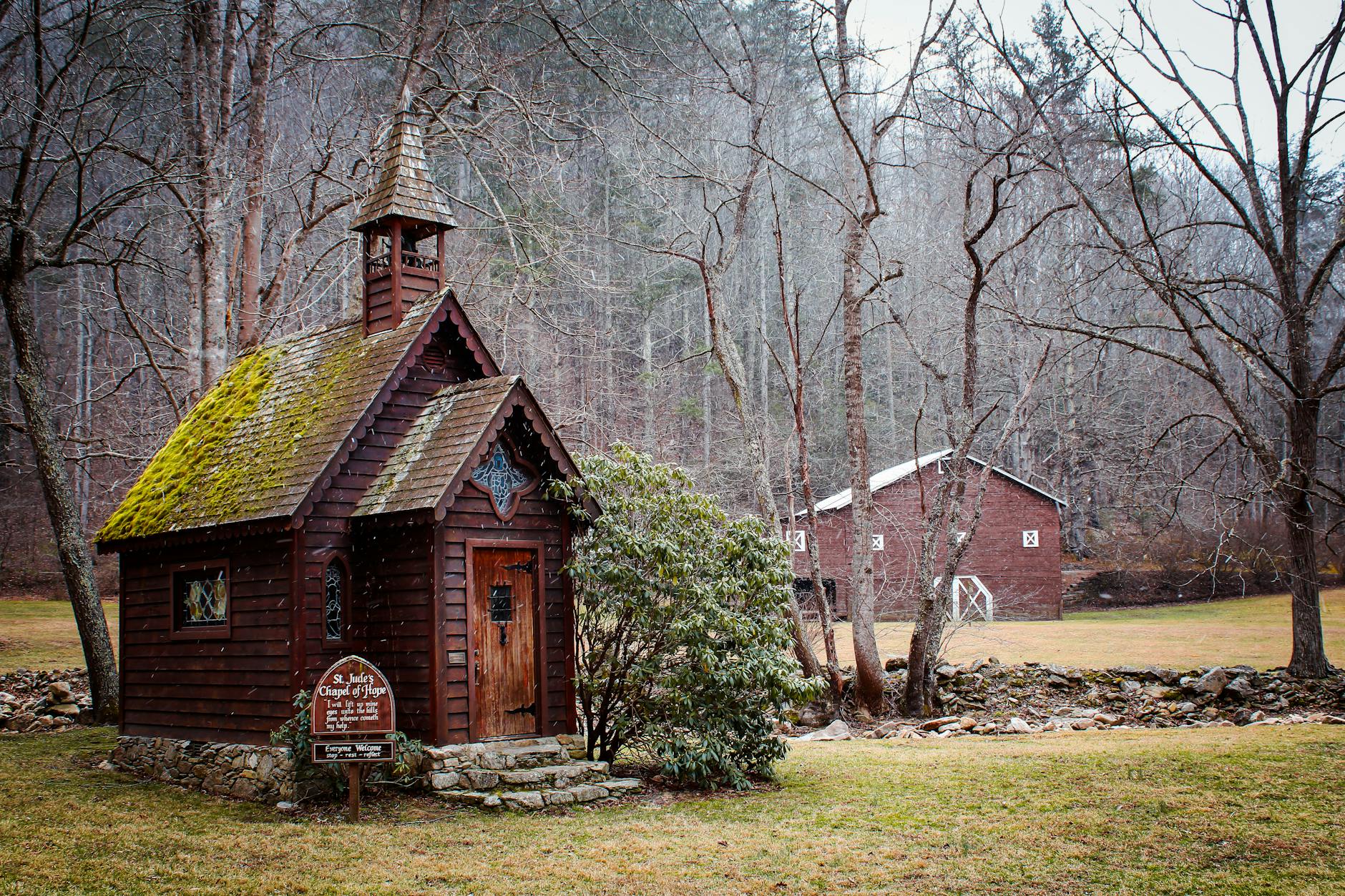 Drewniana kapliczka z mchem na dachu w zimowym lesie pod Świebodzinem