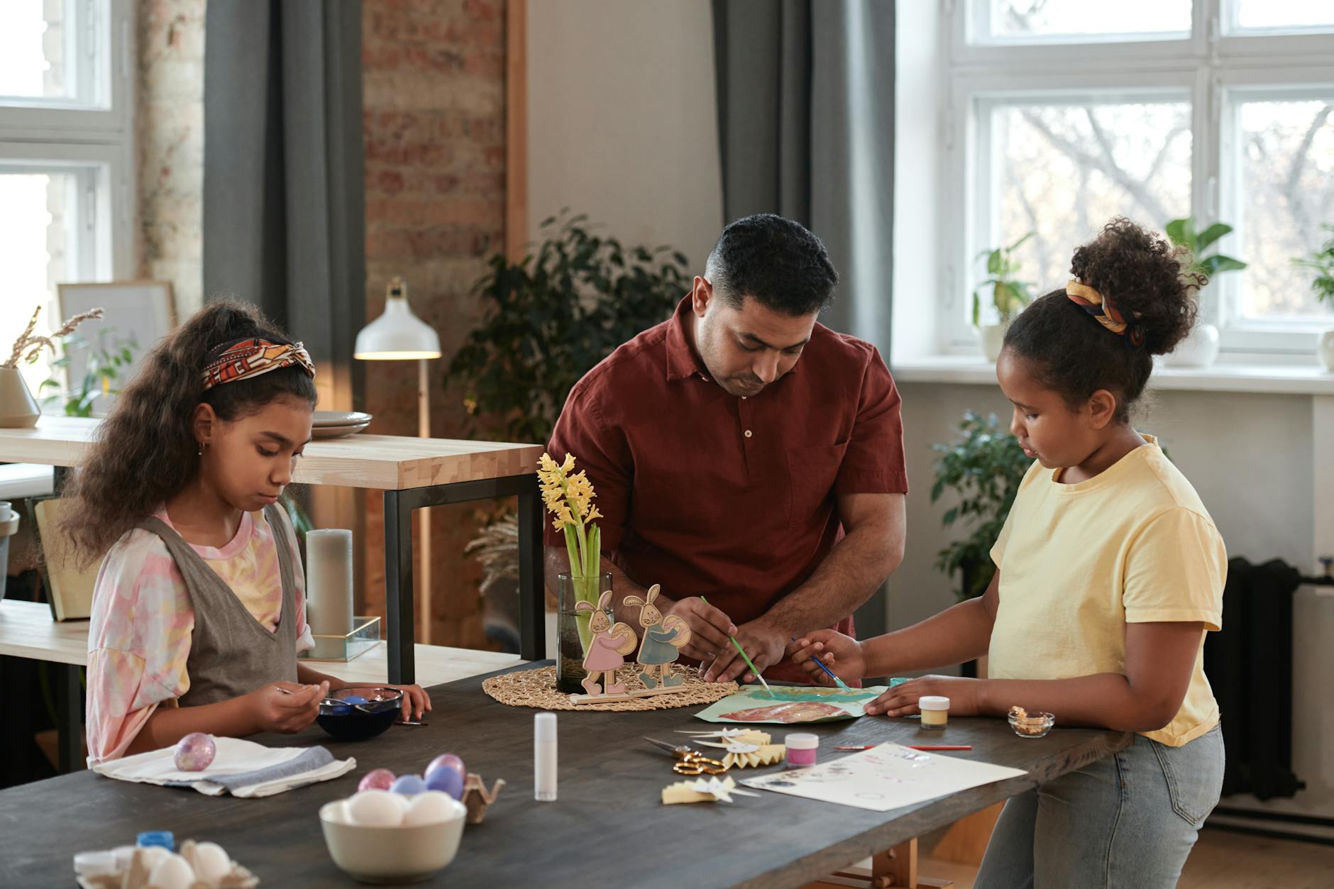Rodzina w domu maluje i zdobi wielkanocne pisanki