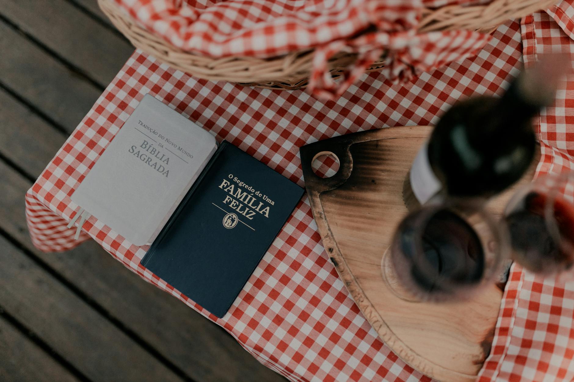 Książki i wino na piknikowym stole w kratę podczas rodzinnego spotkania
