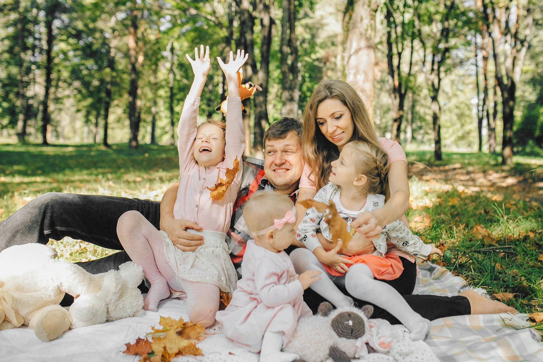 Rodzina z dziećmi bawi się w słoneczny dzień w parku