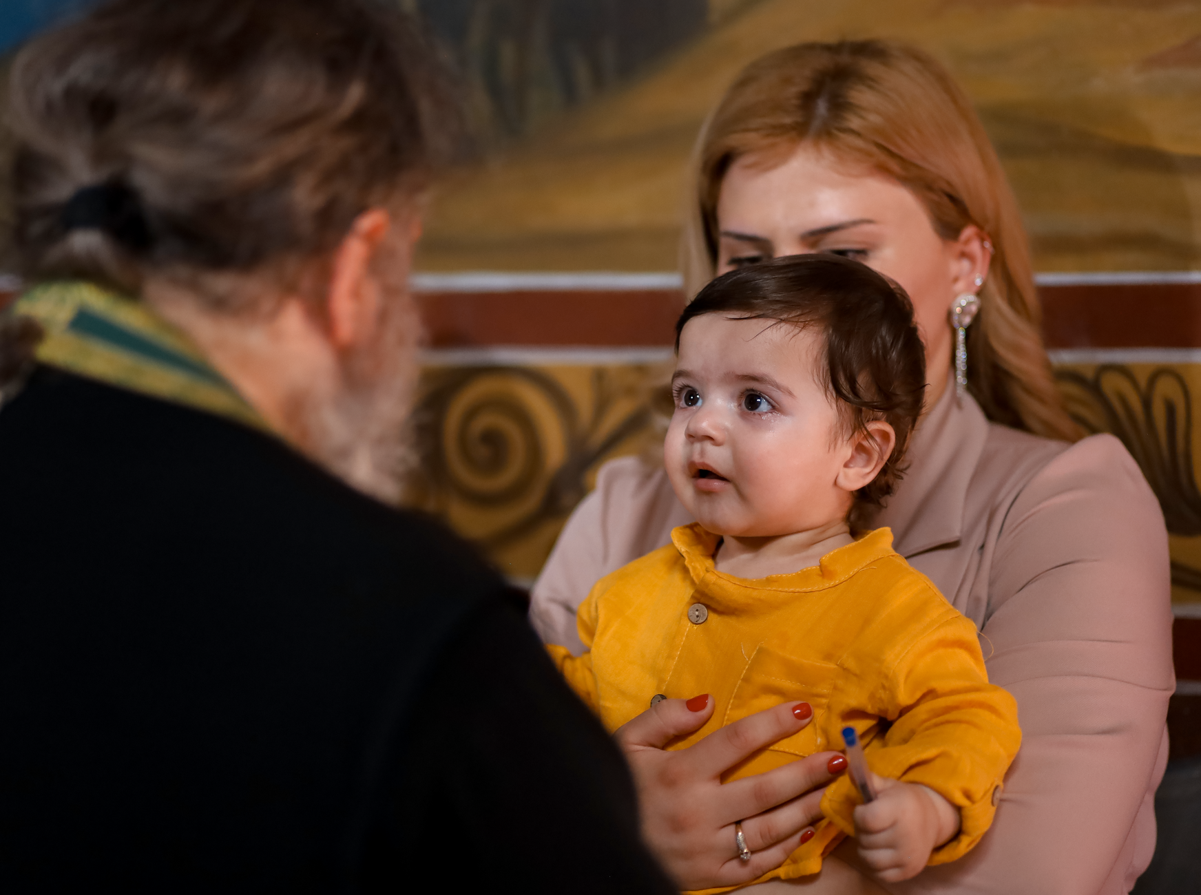 Rodzic trzyma dziecko na rękach podczas wydarzenia w kościele